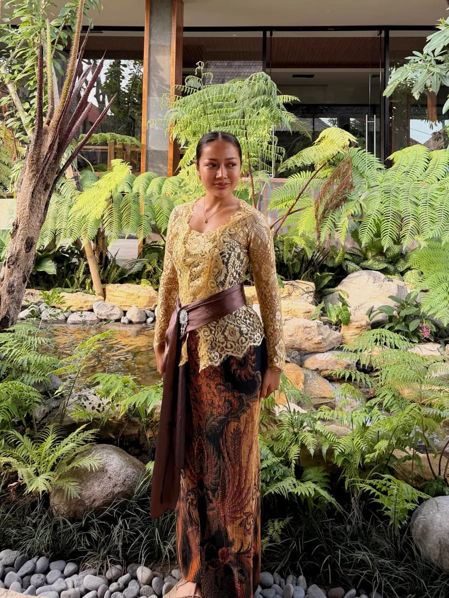 Jean in a traditional Balinese kebaya and batik sarong in a tropical garden